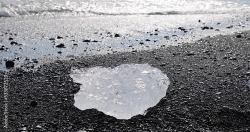 ice on beach with surf and wave at the Breidamerkursandur glacial plain, by Jokulsarlon glacier lagoon on the South Coast of Iceland under climate change and global warming