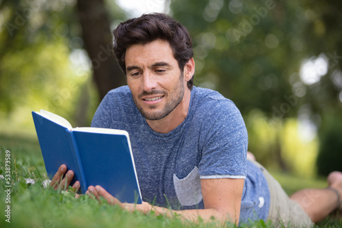 man reading a book on the grass © auremar