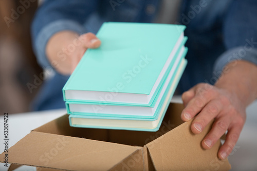 hands are packing books into box