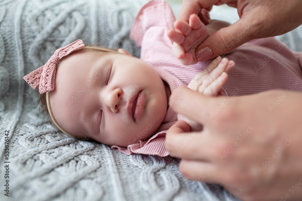 A young and beautiful mother is holding a newborn baby in her arms, taking care of him at home. A young and beautiful mother is holding a newborn baby in her arms, taking care of him at home.