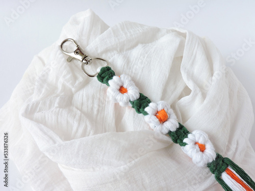 Macrame keychain made of cotton thread. Handcrafted work. Decoration Artworks. Handicrafts. Macrame art for gift. Keychain isolated on a white background. Handmade souvenir. 