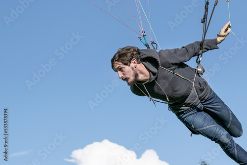 A young man taking off with a paraglider