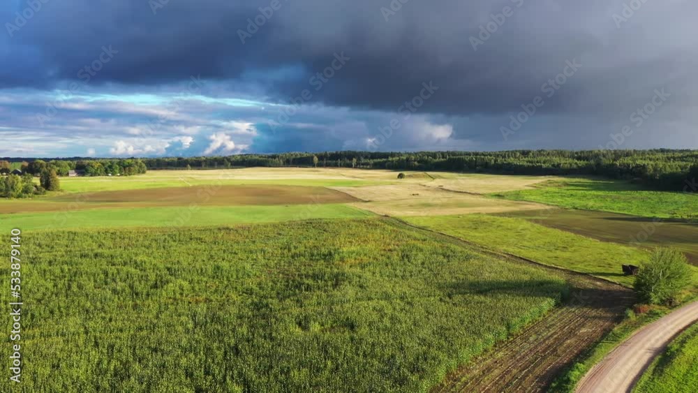 Agricultural fields with stormy weather threatening rain, aerial landing down Agricultural fields with stormy weather threatening rain, aerial landing down