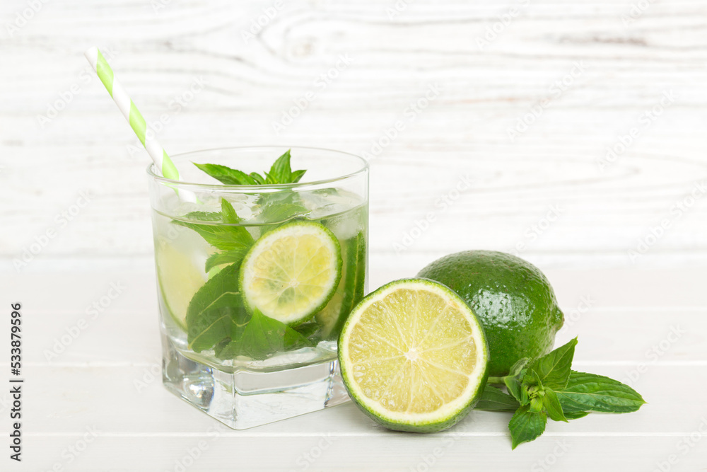 Mojito cocktail. Refreshing mojito cocktail with lime, lemon and mint in a tall glass with a stick Mojito cocktail. Refreshing mojito cocktail with lime, lemon and mint in a tall glass with a stick