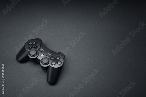 Black console video game joystick controller gamepad isolated on the dark solid black fond background