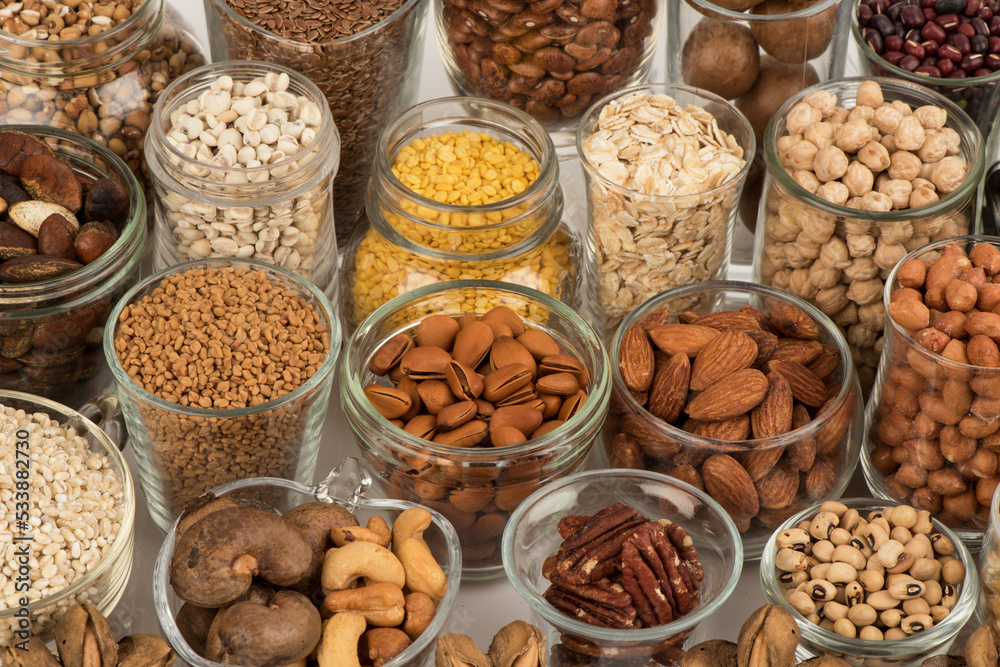 Many cereals such as walnuts, macadamia, green peas, almonds and others isolated on white background.