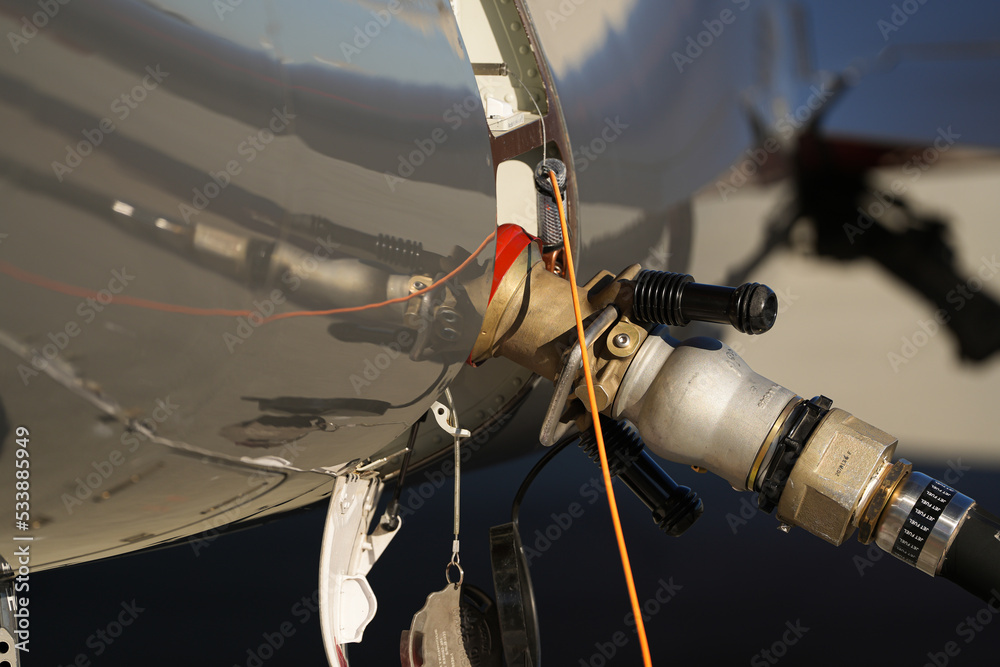 Fuel system of an aircraft on the airport runway. Airplane in the middle of fuelling process. Aviation industry.