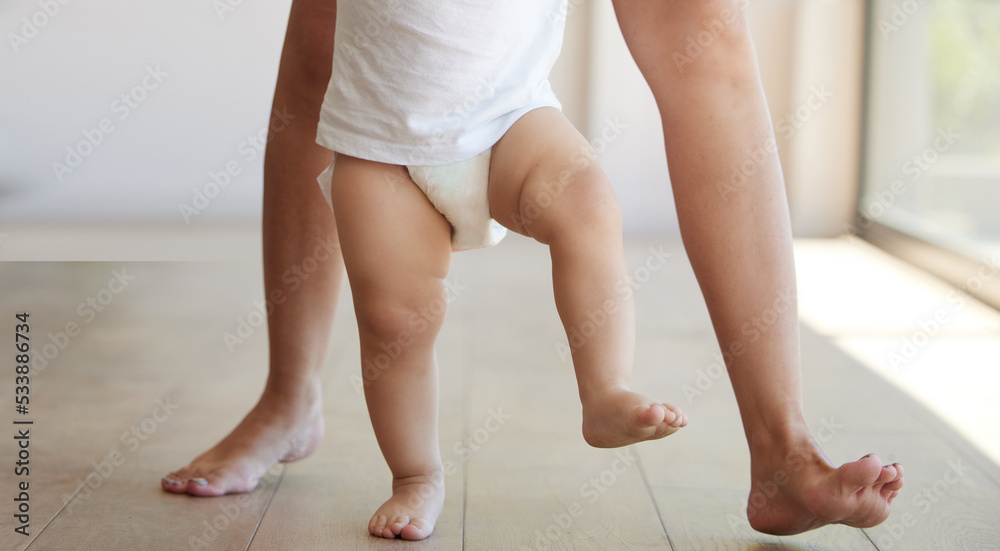 Baby, learning and walking with a child taking its first steps with his mother to learn to walk at home. Feet, legs and balance with a kid stepping forward for growth and development in the house