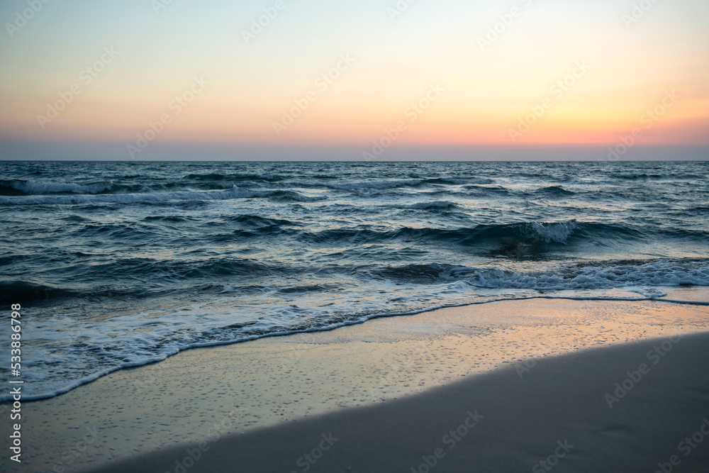 Long exposure by the sea. Waves break against stones. Sunset at the beach. Long exposure at night by the sea. Patara Beach Antalya Turkey