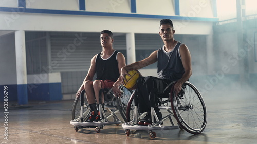 Two disabled handicapped basketball players in wheelchairs. Athletic paralyzed hispanic athletes