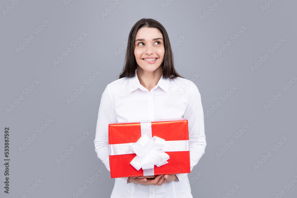 Woman with gift. Portrait of excited young girl holding gift box, isolated grey background. Pretty girl with present. Woman with gift. Portrait of excited young girl holding gift box, isolated grey background. Pretty girl with present.