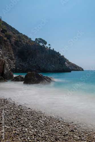 Long exposure by the sea. Waves break against stones. Sunset at the beach. Long exposure at night by the sea. Patara Beach Antalya Turkey