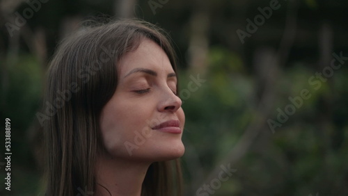 Meditative young woman closing eyes in meditation. Contemplative person opening eyes to sky with HOPE