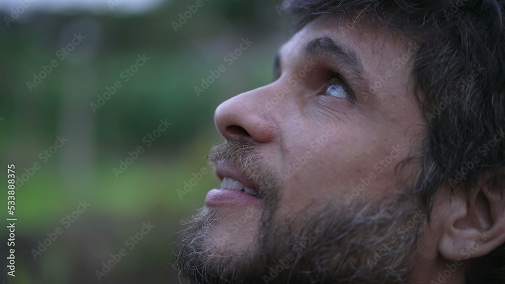 Man looking up at sky smiling having HOPE and FAITH. Person in 30s feeling the presence of GOD feeling FREEDOM