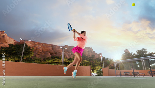 Woman playing tennis in professonal tennis court photo