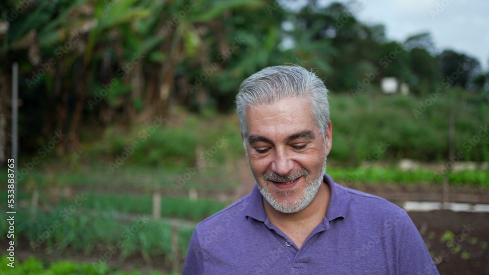 Happy older man walking forward in farm. Senior person portrait face at farmland Happy older man walking forward in farm. Senior person portrait face at farmland