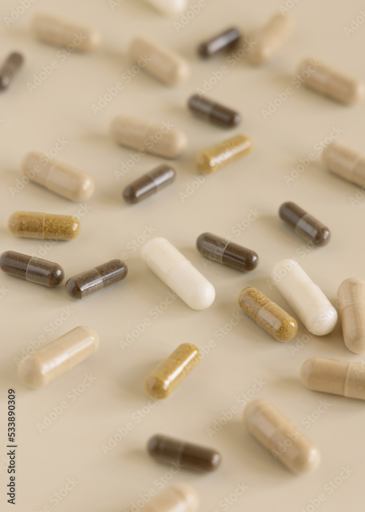 Mix of medical capsules on light beige close up. Taking dietary supplements Mix of medical capsules on light beige close up. Taking dietary supplements