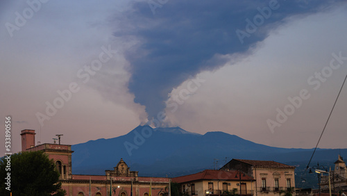 Etna in eruzione con pennacchio di fumo, al tramonto photo