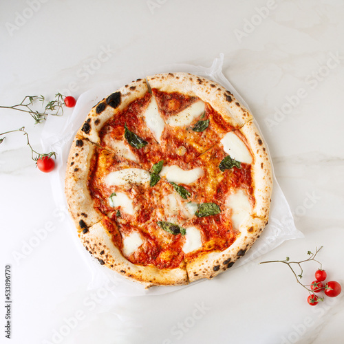 wood fired pizza on a light marble table photo