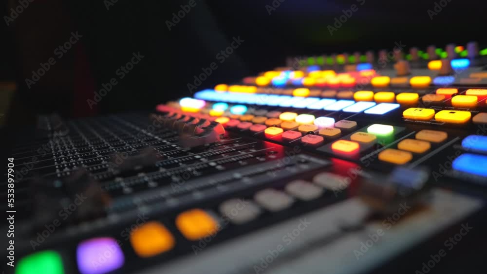 Side view of moving buttons on dj remote or soundboard. Working process in recording studio. Blurred background with brightly glow keys. Musical player at night party. Slow motion Close up Side view of moving buttons on dj remote or soundboard. Working process in recording studio. Blurred background with brightly glow keys. Musical player at night party. Slow motion Close up
