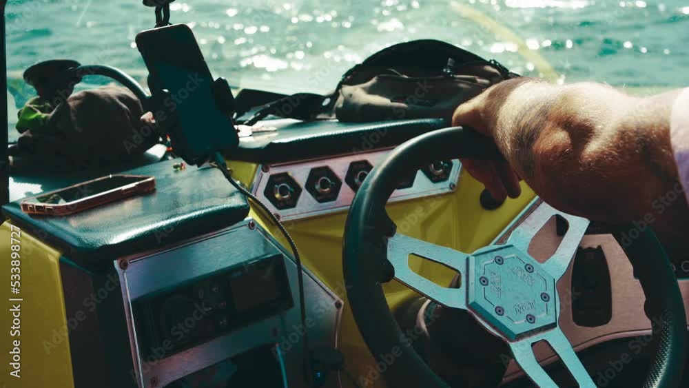 Boat for wakeboarding, wake surfing, water skiing. Closeup of the steering wheel and hands on