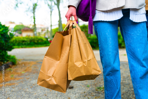 young people walk with take away in hand - paper bags with food in hand - Delivery concept.