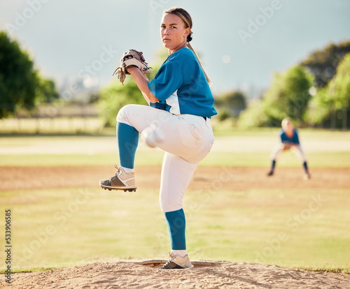 Baseball pitcher, ball sports and a athlete woman ready to throw and pitch during a competitive game or match on a court. Fitness, workout and exercise with a female player training outside on field photo