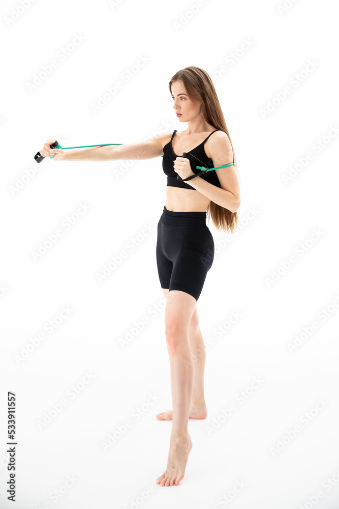 A beautiful girl in sportswear is training with an expander on a white background. Hand exercise