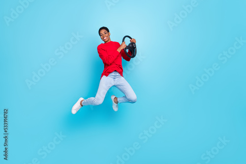 Full length photo of positive millennial short hairdo guy jump drive wear pullover jeans footwear isolated on blue background © deagreez