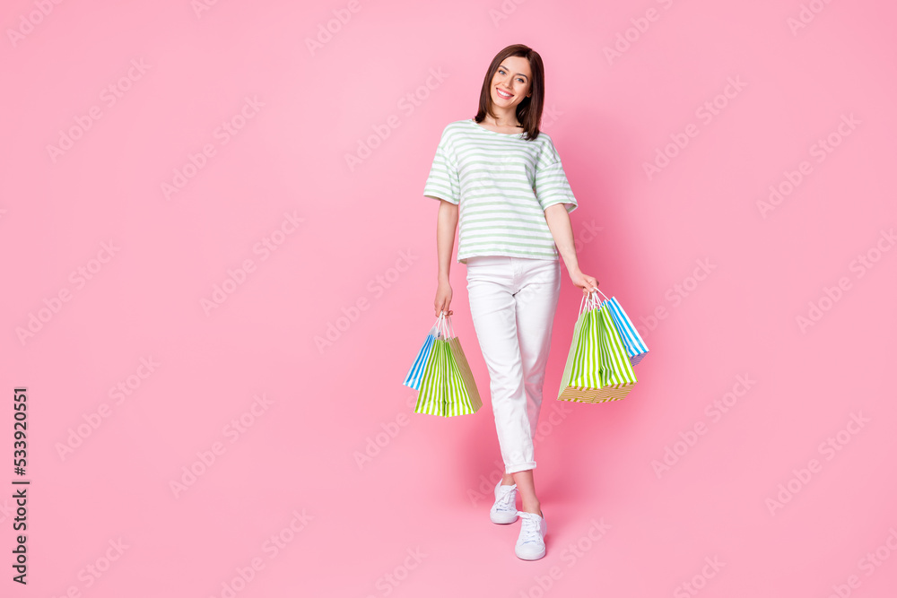 Portrait of pretty gorgeous sweet girl with bob hairdo dressed striped t-shirt hold shopping bag isolated on pink color background Portrait of pretty gorgeous sweet girl with bob hairdo dressed striped t-shirt hold shopping bag isolated on pink color background