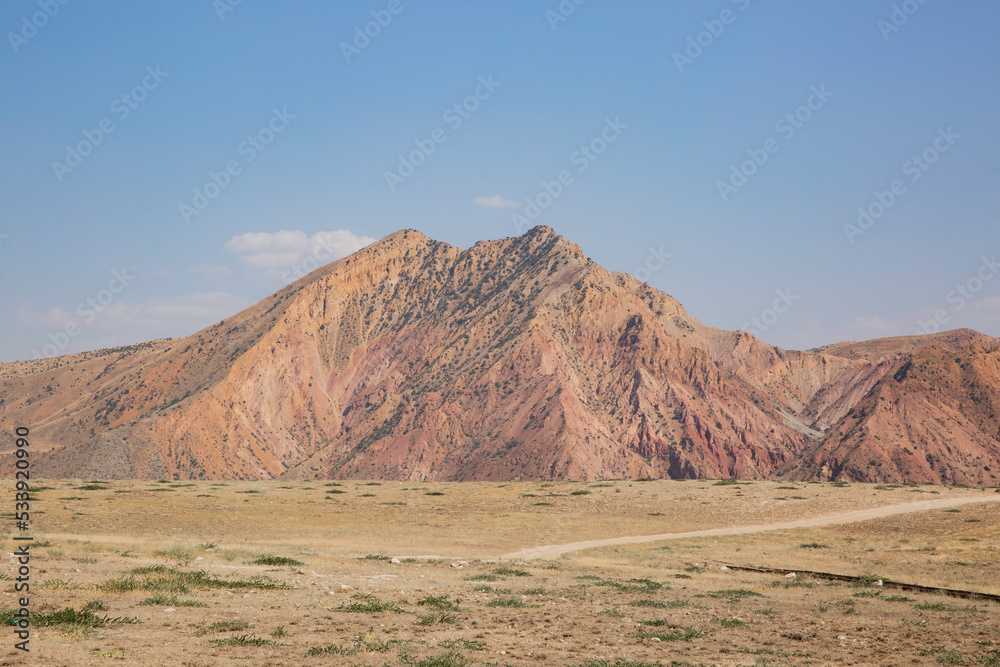 Red rocks with outcrops of geological ferro-magnetic rocks and other minerals in the mountains of Armenia.