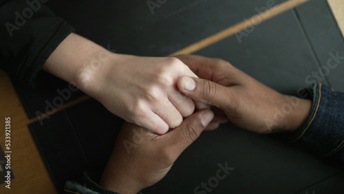 Young diverse couple hands closeup joining together in union. Romantic people holding hands in affection