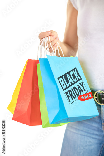 Detail of the hands of an unrecognizable young woman holding colorful bags on a white background - shopping concept, sales, black friday, christmas