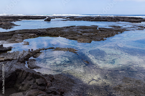 black lava rock shelf and ocean along coast at pu'uhonua o honaunau national historic park hawaii photo