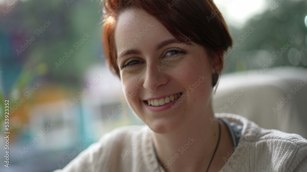 Portrait of a young red hair woman smiling at camera. Happy 20 girl face
