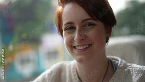 Portrait of a young red hair woman smiling at camera. Happy 20 girl face
