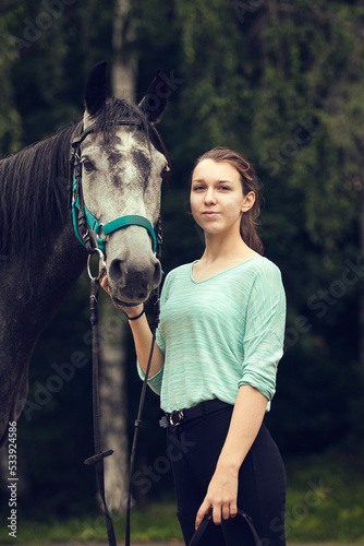 Young girl with grey horse. Portrait close up