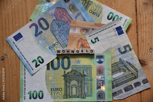 Das Wort Wohngeld mit Holzbuchstaben auf liegenden Euroscheinen photo
