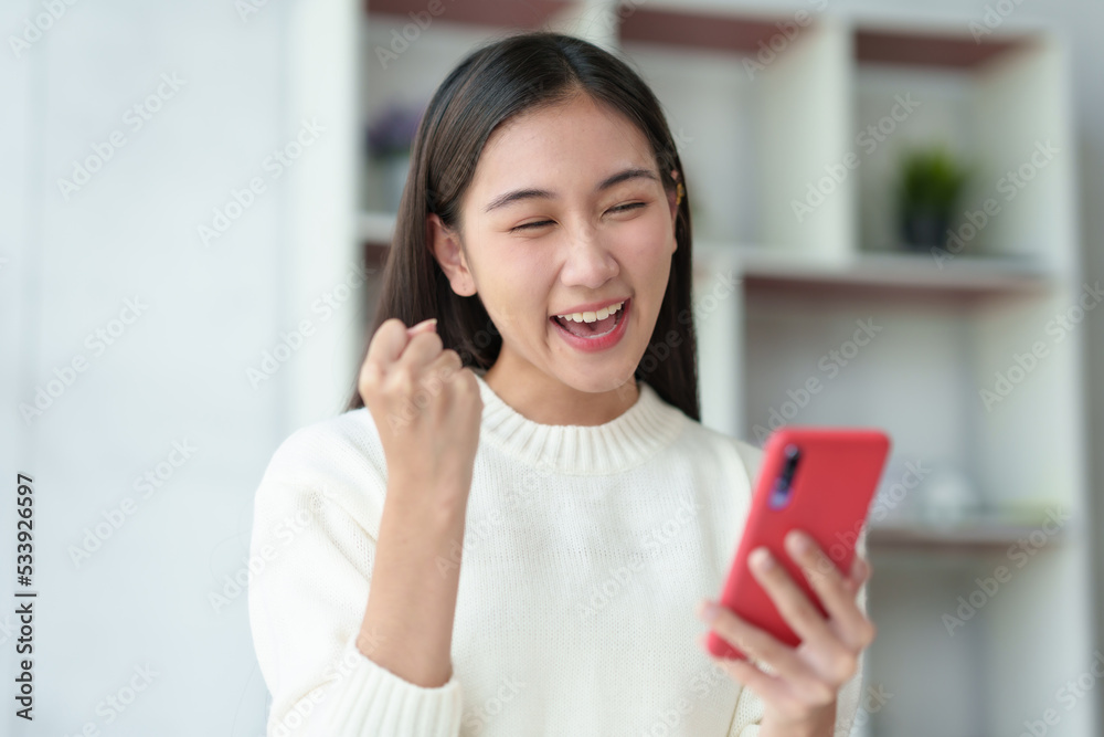 Beautiful Asian businesswoman using smartphone is delighted and excited by the success she has achieved through her office cell phone. Beautiful Asian businesswoman using smartphone is delighted and excited by the success she has achieved through her office cell phone.