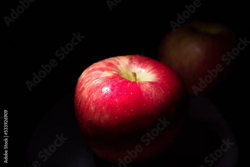 fresh red apple On a black background with water droplets, lights are falling with space for text.