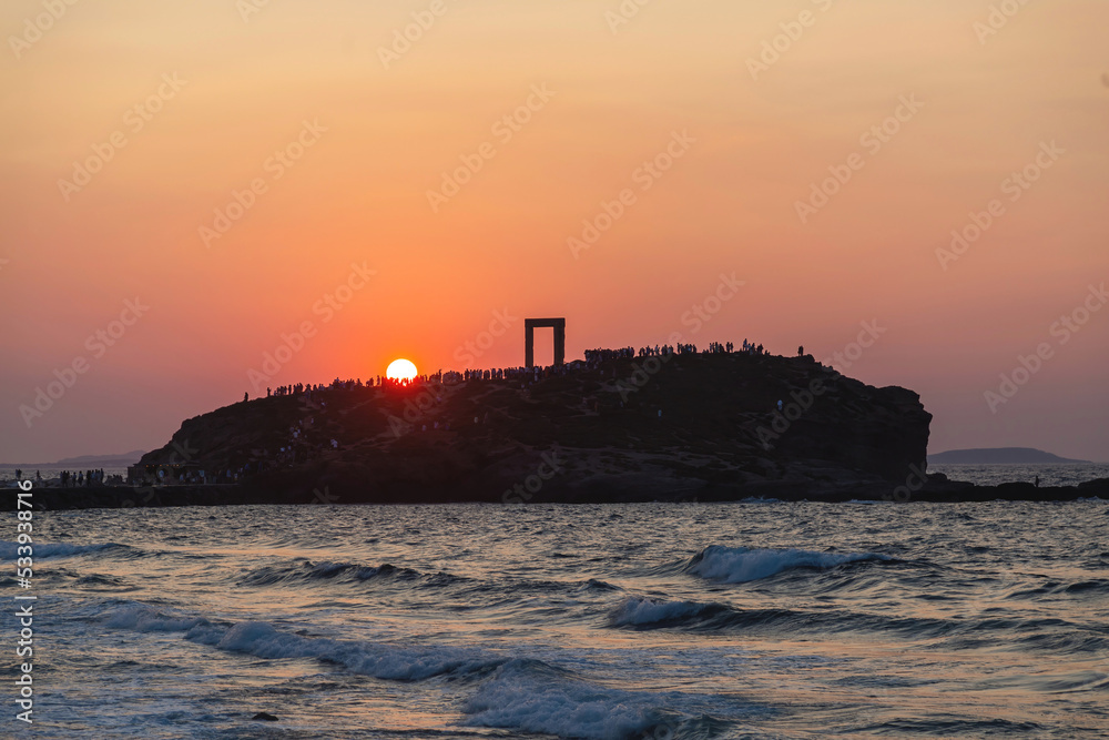 Naxos island, sunset over Temple of Apollo, Cyclades Greece. People admire the sundown background.