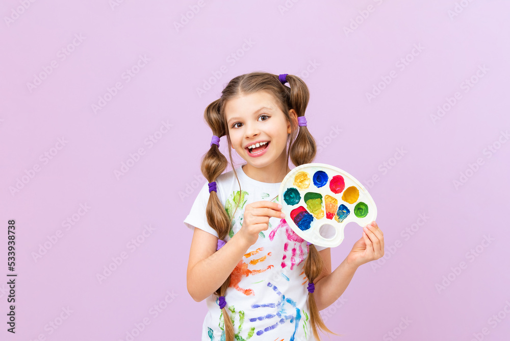 A child with paints on an isolated background, a little girl in a T-shirt with hand prints with paints, a passion for painting. A child with paints on an isolated background, a little girl in a T-shirt with hand prints with paints, a passion for painting.