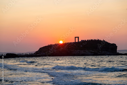 Naxos island, sunset over Temple of Apollo, Cyclades Greece. Visitors admire the sundown background.