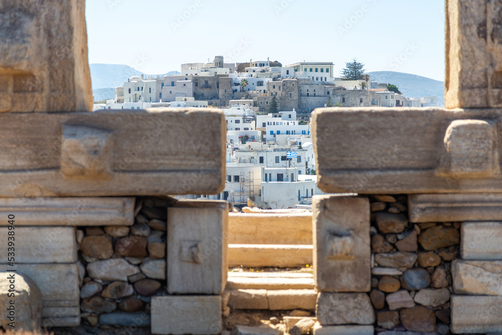 Naxos island, Greece. Chora buildings view through Portara, the marble gate of Apollo Temple