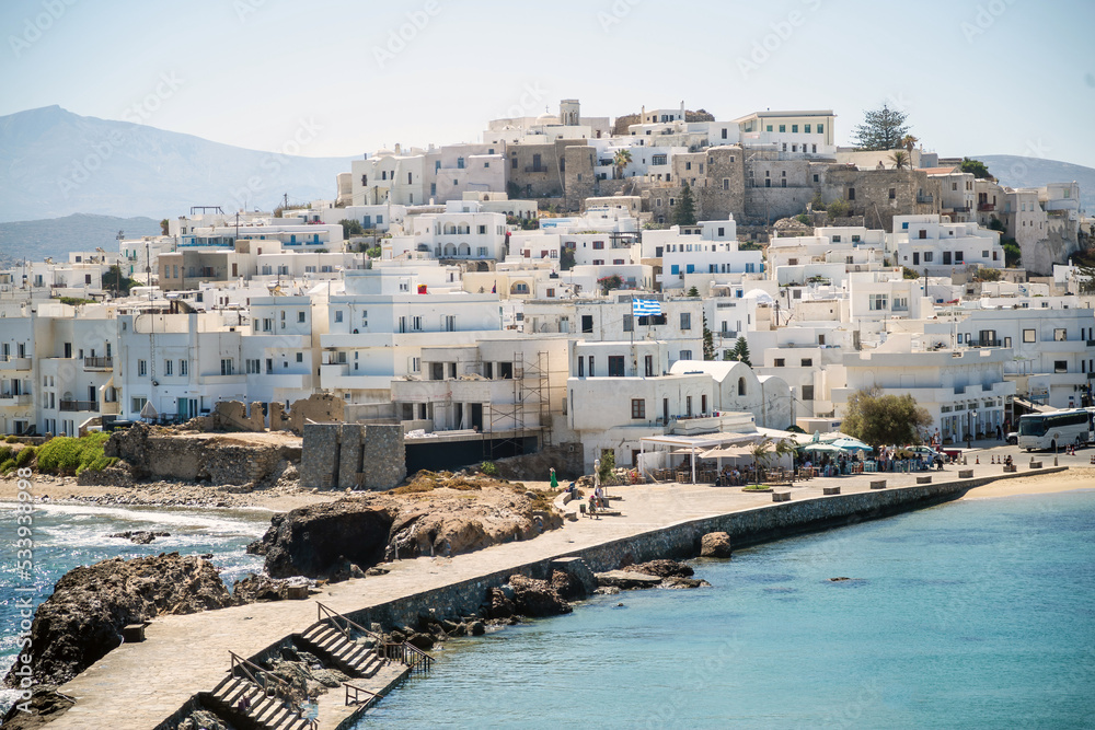 Greece, Naxos harbor, Cyclades islands. View from ship of houses, calm sea, blue sky, sunny day.