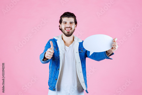 Man holding a blank ideapad and showing thumb up photo