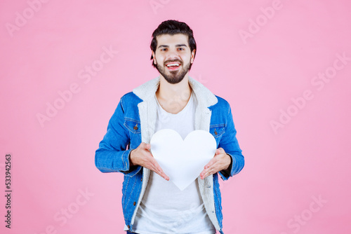 Man holding and presenting a blank heart figure with smiles photo
