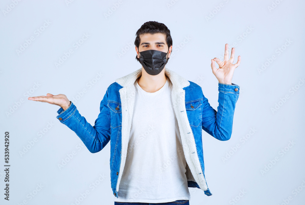 Naklejka premium Man in black mask showing enjoyment sign and feeling good