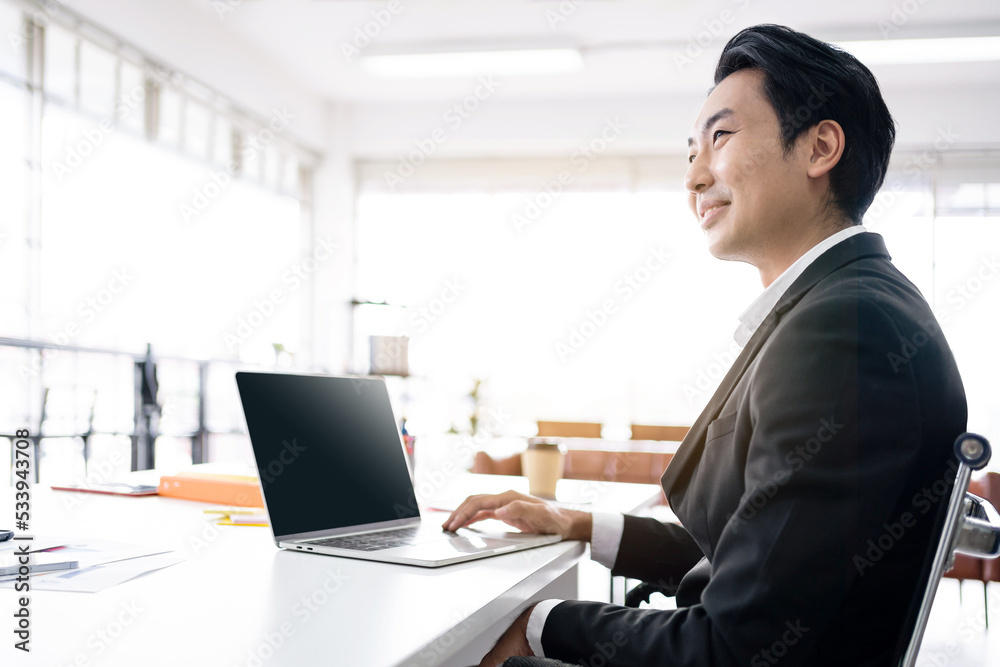 Professional confident Asian businessman smile and works on a laptop computer while meeting in the office area. businessman entrepreneur with connection and discussion skills. Image with copy space. Professional confident Asian businessman smile and works on a laptop computer while meeting in the office area. businessman entrepreneur with connection and discussion skills. Image with copy space.
