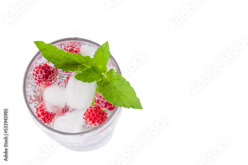Carbonated drinks with fresh berries, mint and ice. Fresh cold sparkling bubble water with mint, raspberry, black and red currant in transparent glass with ice, top view macro. Food and drink concept